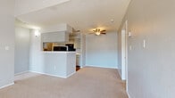 This 2-bedroom, 2-bathroom residence offers a functional and comfortable single-floor layout. The open-concept living room is a standout feature, boasting soaring vaulted ceilings, soft neutral carpet, and a classic tiled fireplace that serves as a natural focal point. A ceiling fan adds comfort to the adjoining dining area, which flows seamlessly toward the kitchen. The kitchen is galley-style with warm hardwood-style flooring, gray cabinetry, a pass-through bar window, black appliances, and a convenient pantry for additional storage. An entrance foyer welcomes residents upon arrival. Both bedrooms are well-proportioned, carpeted, and finished in light, neutral tones. The primary bedroom benefits from a large window that invites natural light and features its own dedicated closet with built-in shelving. The second bedroom is equally comfortable and also includes a walk-in closet with dual shelving units. Each bathroom is clean and functional, featuring white vanities with countertops, a tiled tub-shower combination, and wood-style flooring. Textured ceilings are consistent throughout the home, adding a classic residential character. The overall palette of soft grays and warm neutrals creates a cohesive and move-in-ready atmosphere.