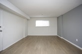 This single-floor unit offers a practical and well-organized layout designed for comfortable everyday living. The living area is spacious and open, featuring durable wood-look laminate flooring, neutral white walls, and a textured ceiling. A window fitted with horizontal blinds allows natural light to filter in, while a front entry door provides direct access to the space. A stacked washer and dryer unit is conveniently located near the entry.

The kitchen is efficiently designed with white cabinetry offering ample upper and lower storage, dark laminate countertops, and under-cabinet lighting. It is equipped with a stainless steel double-basin sink, a stainless steel dishwasher, and a black electric range, providing all the essentials for meal preparation.

The two bedrooms are finished with plush carpeting and neutral-toned walls, each featuring windows with blinds that allow for natural light and privacy. One bedroom includes a sliding-door closet with a hanging rod, offering practical storage. The full bathroom is clean and bright, featuring a white tub-shower combo with tiled surround, a toilet, a vanity with under-sink storage, and wood-look flooring that ties the space together cohesively.