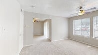 This well-organized one-bedroom, one-bathroom unit in Austin, TX offers a thoughtfully designed single-floor layout that makes excellent use of its compact footprint. The living area welcomes you through a paneled front door and features plush carpeting, a ceiling fan with light fixture, a built-in wall shelf, and a window with blinds that allow natural light to filter in. The space flows seamlessly into the bedroom, which is carpeted and includes its own ceiling fan, a walk-in closet, and vertical blinds that open to bring in additional light. The kitchen is efficiently appointed with white cabinetry, a tile backsplash, a double-basin sink, and a full suite of appliances including a stainless steel dishwasher, an electric range with overhead microwave, and a black refrigerator, all set on wood-look flooring. The bathroom offers a clean, functional design with a tiled tub-shower combination, a white vanity, and matching wood-look flooring that ties the wet areas together. Textured ceilings are consistent throughout the unit, lending a classic residential feel. The overall ambiance is bright, neutral, and move-in ready, making this unit a practical and comfortable home in Austin.