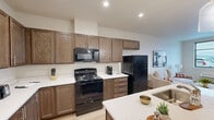 Located at 2635 Nez Perce Drive in Lewiston, Idaho, this thoughtfully designed one-bedroom, one-bathroom residence offers a comfortable and functional single-floor layout. The open-concept living, dining, and kitchen area creates a seamless flow throughout the main living space, anchored by light hardwood-style flooring and neutral walls that lend a clean, modern aesthetic.

The kitchen is a standout feature, boasting rich dark walnut-toned cabinetry with sleek hardware, white quartz countertops, and a large center island with an undermount sink and pendant lighting overhead. Black appliances, including a range, over-the-range microwave, and refrigerator, complement the warm cabinetry tones. Ample upper and lower cabinet storage makes the kitchen as practical as it is attractive.

The living room is bright and welcoming, with a large window offering outdoor views and allowing natural light to fill the space. The bedroom is a comfortable retreat, featuring carpet flooring, a ceiling fan, and a generous window with exterior views. Two closets provide excellent storage throughout the unit. The bathroom is clean and simply finished, with a tub-shower combination and light wood-style flooring. An in-unit laundry area adds everyday convenience to this well-appointed residence.