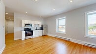 Located at 3 State St in Schenectady, NY, this efficiently designed one-bedroom, one-bathroom unit offers a well-planned layout across a single floor. Warm hardwood flooring flows throughout the living areas and bedroom, lending a cohesive and inviting aesthetic to the space.

The open-concept living and kitchen area is bright and functional, featuring recessed lighting, a large window that invites natural light and offers views of the surrounding cityscape, and baseboard heating. The kitchen is outfitted with white shaker-style cabinetry, a classic subway tile backsplash, dark countertops, and a full suite of stainless steel appliances including a refrigerator, range, and microwave.

The bedroom is a cozy and practical space with light gray walls, hardwood floors, a window with city views, and baseboard heating. Its six-panel white door and clean finishes give it a polished, move-in-ready feel.

The bathroom is a standout feature, showcasing a classic black-and-white basketweave tile floor, crisp white subway-tiled shower with a sleek black-framed sliding glass door and built-in niche, a pedestal sink, and matte black hardware accents — a timeless design with a modern edge.

A hallway connects the rooms, completing this thoughtfully laid-out urban residence.