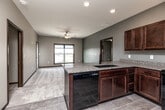 Located at 2861 Prairie Hill Dr in Marion, Iowa, this well-appointed two-bedroom, two-bathroom residence offers a thoughtfully designed single-floor layout. The open-concept living area seamlessly connects the kitchen, dining, and living spaces, creating a bright and functional hub for daily life. The kitchen is a standout feature, showcasing rich dark cabinetry, granite countertops, a peninsula island with an undermount sink, and black appliances including a refrigerator, range, and dishwasher. Tile flooring grounds the kitchen and extends into the laundry and bathroom areas, while plush carpet adds warmth to the living room and bedrooms. The primary bedroom is generously sized with large windows offering outdoor views and a ceiling fan overhead. Both bedrooms feature neutral tones, soft carpet, and access to well-appointed closets. The bathrooms are finished with tile flooring, dark wood vanities, and clean fixtures. A dedicated laundry room adds everyday convenience. Throughout the home, dark wood trim, neutral wall tones, and consistent finishes create a cohesive, modern aesthetic. Three closets provide ample storage across the floor plan.