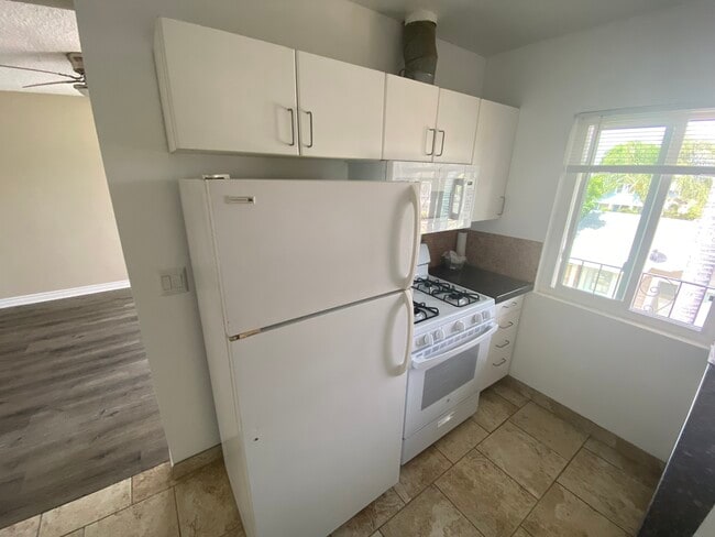 kitchen with stove, microwave and refrigerator - 6230 Milton Ave