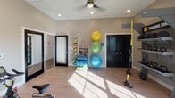 Located at 6315 Wiley Dr in Simpsonville, SC, this single-floor fitness studio is thoughtfully designed to support a wide range of workout modalities. The space features vaulted ceilings that lend an open, airy feel, complemented by recessed lighting and ceiling fans that maintain comfort during active use. Light wood-tone flooring runs throughout, providing a clean, durable surface suited for both equipment-based and floor exercises.

A full-length mirrored wall with a mounted barre rail runs along one side of the studio, making the space well-suited for dance fitness, stretching, and barre classes. A row of stationary cycling bikes faces a large wall-mounted flat-screen television, creating a dedicated spin area. TRX suspension trainers are anchored nearby, adding versatility for bodyweight training.

An organized equipment rack holds stability balls, resistance bands, yoga mats, and medicine balls, keeping accessories accessible and neatly stored. A freestanding weight rack adds further strength-training capability. Multiple windows allow generous natural light to fill the room while offering views of the surrounding outdoor landscape. The neutral wall tones and streamlined layout create a focused, professional atmosphere suited for group or individual fitness sessions.