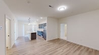 This well-appointed 2-bedroom, 2-bathroom residence at 4000 Emerson Dr in Mount Wolf, PA offers a thoughtfully designed single-floor layout. The open-concept living and kitchen area is anchored by light wood-look vinyl plank flooring throughout, creating a clean and cohesive aesthetic. The modern kitchen is a standout feature, showcasing gray shaker-style cabinetry, white quartz countertops, a center island with a double-basin sink, stainless steel appliances including a range, microwave, and refrigerator, and pendant lighting above the island. Vertical blinds allow for natural light control in the living area. The spacious primary bedroom features plush carpeting, a ceiling fan, a large window for natural light, and a double-door closet offering generous storage. The second bedroom is equally well-sized with soft carpet and dedicated closet space. Both bathrooms are finished with light wood-look flooring; one includes a walk-in shower with chrome fixtures, and the other features a full tub-shower combo with a dark-toned vanity. A dedicated in-unit laundry area with a full-size washer and dryer adds everyday convenience to this move-in-ready home.