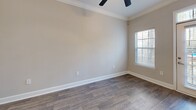 Located at 2676 Milscott Dr in Decatur, GA, this well-appointed one-bedroom, one-bathroom unit offers a thoughtfully designed single-floor layout. The open-concept kitchen and living area serves as the heart of the home, featuring rich hardwood-style flooring, crown molding, and a ceiling fan. The kitchen is equipped with stainless steel appliances — including a refrigerator, range, microwave, and dishwasher — complemented by white shaker cabinetry, a classic subway tile backsplash, and granite countertops with an integrated sink on the peninsula island. Natural light fills the living area through a glass-panel entry door with transom window and an adjacent window. The bedroom is carpeted for comfort, includes a ceiling fan, and connects directly to the bathroom, which offers a granite-topped vanity, wood-look tile flooring, and a tiled soaking tub/shower combination. A generously sized walk-in closet with wire shelving provides ample storage. Additional spaces include a pantry, a utility room, and a second closet. Neutral warm-gray tones throughout create a clean, cohesive aesthetic well-suited for comfortable everyday living.