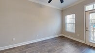Located at 2676 Milscott Dr in Decatur, GA, this well-appointed one-bedroom, one-bathroom unit offers a thoughtfully designed single-floor layout. The open-concept kitchen and living area serves as the heart of the home, featuring rich hardwood-style flooring, crown molding, and a ceiling fan. The kitchen is equipped with stainless steel appliances — including a refrigerator, range, microwave, and dishwasher — complemented by white shaker cabinetry, a classic subway tile backsplash, and granite countertops with an integrated sink on the peninsula island. Natural light fills the living area through a glass-panel entry door with transom window and an adjacent window. The bedroom is carpeted for comfort, includes a ceiling fan, and connects directly to the bathroom, which offers a granite-topped vanity, wood-look tile flooring, and a tiled soaking tub/shower combination. A generously sized walk-in closet with wire shelving provides ample storage. Additional spaces include a pantry, a utility room, and a second closet. Neutral warm-gray tones throughout create a clean, cohesive aesthetic well-suited for comfortable everyday living.