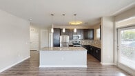 This well-appointed 2-bedroom, 2-bathroom home in Columbia, SC offers a functional and modern single-floor layout. The open-concept kitchen serves as the heart of the home, showcasing rich dark cabinetry, granite countertops, a mosaic tile backsplash, and a full suite of stainless steel appliances including a range, microwave, dishwasher, and refrigerator. A large center island with an undermount sink and pendant lighting above provides both prep space and a natural gathering point. Wood-look flooring flows throughout the main living and kitchen areas, lending warmth and cohesion to the space. The two bedrooms are carpeted for comfort, each featuring a ceiling fan, natural light from windows with blinds, and generous closet storage — with three closets total throughout the home. The primary bedroom offers a comfortable, well-proportioned retreat. Both bathrooms are finished with granite-topped dark vanities and tile flooring; one features a tub-shower combination with full tile surround, while the second offers a clean, functional design. Neutral tones and clean lines throughout create a bright, move-in-ready atmosphere suited for a variety of lifestyles.