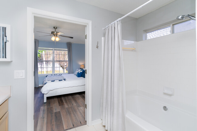 A nice wide soaking tub with a shower along with a medicine cabinet, towels, toiletries. - 6464 Starfish Cv