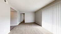 Located at 7850 Everett Ave in Kansas City, KS, this one-bedroom, two-bathroom unit offers a practical and well-organized single-floor layout. The entrance opens into a carpeted living area featuring neutral gray walls, a textured ceiling, and a large sliding vertical-blind window treatment that allows natural light to filter in. The space flows seamlessly from the entrance into the main living room, which provides a comfortable, open feel. The kitchen is equipped with warm wood-toned cabinetry, dark countertops, and a full suite of white appliances including a refrigerator, electric range, dishwasher, and over-range ventilation hood, all set atop durable wood-look luxury vinyl plank flooring. The bedroom features plush carpeting, a sliding double-panel closet for storage, and a window that brings in natural light. Both bathrooms are finished with wood-look LVP flooring; one includes a full tub-shower combo with brushed nickel fixtures and a clean white surround. Throughout the unit, consistent light gray paint, white trim, and a mix of carpet and LVP flooring contribute to a cohesive, move-in-ready aesthetic. The thoughtful layout maximizes the use of every square foot within this efficiently sized home.