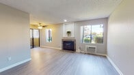 Located at 2130 S Santa Fe Ave in Vista, California, this single-floor residence offers a well-organized layout with thoughtfully updated finishes throughout. The open living area serves as the heart of the home, anchored by a stone-surround fireplace with a classic white mantle and complemented by light wood-style flooring that flows seamlessly through the space. Large windows on multiple walls invite abundant natural light and provide views of the surrounding greenery and neighborhood, while a ceiling fan adds comfort and functionality overhead. A wall-mounted A/C unit ensures year-round climate control.

The kitchen is efficiently laid out in a galley style, featuring gray shaker cabinetry, light granite-style countertops, a stainless steel sink, and a full-size stainless steel refrigerator, with a dishwasher included for added convenience. The kitchen opens toward the main living and dining areas, making the space feel connected and functional.

The bedrooms are comfortably sized with neutral-toned walls, textured ceilings, and light to medium-tone wood-style flooring, each featuring windows that bring in natural daylight. The bathrooms are clean and well-appointed — one includes a soaking tub and shower combination with a chrome fixture, while the other features a shaker-style vanity with a white sink, large mirror, and additional storage cabinetry above.