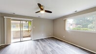 Located at 1005 McCord Rd in Valparaiso, Indiana, this single-floor home offers a clean, modern aesthetic throughout. The interior is unified by light luxury vinyl plank flooring that flows seamlessly from room to room, complemented by neutral warm-beige and gray wall tones that create a calm, cohesive atmosphere.

The living area is generously proportioned, featuring a ceiling fan with integrated lighting, large sliding glass doors that open to an outdoor patio, and an additional window that fills the space with natural light while providing views of the surrounding greenery.

The kitchen is well-appointed with crisp white cabinetry, light quartz-style countertops, and a full suite of stainless steel appliances including a refrigerator, range, over-the-range microwave, and dishwasher. A stainless steel sink with a modern brushed nickel faucet completes the functional layout.

Multiple bedrooms continue the consistent design language, each equipped with ceiling fans, neutral walls, and windows that invite natural light and outdoor views. The bathroom is finished in white, featuring a vanity with cabinet storage, a tub-shower combo, and coordinating LVP flooring. Throughout the home, clean lines and updated finishes create a welcoming, move-in-ready environment.