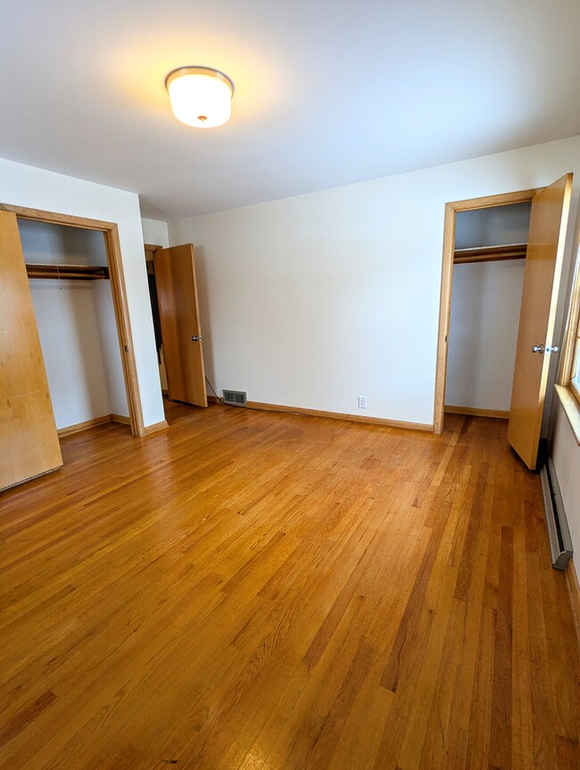 El dormitorio principal cuenta con dos armarios y pisos de madera originales. - 910 Maple St