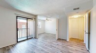 Located at 8131 E Harry St in Wichita, Kansas, this one-bedroom, one-bathroom unit offers a thoughtfully designed layout across a single floor. Light wood-style flooring runs throughout the entire space, creating a cohesive and clean aesthetic.

The open living area is bright and airy, benefiting from a sliding glass door that opens to a private balcony, allowing natural light to fill the room. A ceiling fan adds both style and function overhead, while the textured ceiling adds a classic touch to the interior.

The kitchen is well-appointed with white shaker-style cabinetry, light granite-look countertops, stainless steel appliances including an electric range and over-the-range microwave, and a black refrigerator. The galley-style layout maximizes efficiency and provides ample storage and prep space.

The spacious primary bedroom is generously proportioned, offering plenty of room to furnish comfortably. It features a closet with built-in shelving, a window with blinds for natural light and privacy, and a ceiling fan for year-round comfort.

The bathroom is clean and functional, featuring a white vanity with storage, a framed mirror, and a full bathtub and shower combination with wood-style tile flooring. Every room in this unit reflects a fresh, updated finish throughout.
