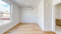 Located at 1 Martin Luther King Jr Drive in Jersey City, NJ, Unit 304 is a thoughtfully designed studio-style unit that maximizes its compact footprint through clean architectural lines and a modern aesthetic. Light hardwood flooring runs throughout the main living area, complementing the crisp white walls and creating a bright, cohesive atmosphere. A wall-mounted mini-split HVAC unit provides efficient climate control, while recessed lighting illuminates the space evenly.

The kitchen is a standout feature, equipped with stainless steel appliances including a gas range, microwave, and refrigerator. Two-tone cabinetry pairs white upper cabinets with warm wood-grain lower units beneath a white quartz countertop. A matte black pull-down faucet adds a contemporary accent to the undermount sink, with a dishwasher completing the full appliance suite.

The bathroom carries the same modern design language, featuring large-format marble-look tile on both the walls and tub surround. A soaking tub with an integrated shower, matte black fixtures, and a floating wood-grain vanity topped with white quartz and framed by a rectangular black-trimmed mirror round out the polished, spa-like finish. A window in the main area allows natural light and views of the surrounding Jersey City neighborhood.
