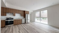 Located at 13716 Victory Blvd in Van Nuys, Los Angeles, this modern single-story unit offers a thoughtfully designed layout across a compact yet efficient floor plan. Light wood-look flooring runs seamlessly throughout, complementing the clean white walls and recessed lighting that give the space a bright, contemporary feel.

The open-concept kitchen and living area form the heart of the unit. The kitchen is outfitted with rich walnut-toned flat-panel cabinetry extending to the ceiling for ample storage, light-toned countertops, and a full suite of stainless steel appliances including a range, dishwasher, and refrigerator. A large sliding glass window-wall at the end of the living area floods the space with natural light and provides views of the surrounding exterior.

The generously sized bedroom is bright and airy, featuring a large window with outdoor views and a full-width mirrored sliding closet that enhances the sense of space. The clean, neutral palette throughout the room creates a calm and functional environment.

Additional features include a dedicated closet for storage and a well-placed entry area. The unit's modern design, quality finishes, and efficient use of space make it a practical and stylish home in the heart of the San Fernando Valley.