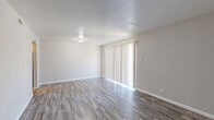 This two-story, two-bedroom, two-bathroom home offers a practical and efficient layout spread across two floors. The main level houses the combined living and dining area, kitchen, and a pantry, while the upper level is dedicated to the bedrooms, bathrooms, and generous closet storage with five closets in total.

The open living and dining area is bright and welcoming, featuring wood-style laminate flooring, neutral-toned walls, and a textured ceiling. A large sliding glass door with vertical blinds fills the room with natural light and provides outdoor access. The kitchen is well-equipped, showcasing granite-style countertops, white cabinetry with brushed nickel hardware, a white subway tile backsplash, and black appliances including an electric range with overhead ventilation. The wood-style flooring carries throughout the kitchen as well.

The bedrooms are comfortably sized, with the primary bedroom offering a generous footprint. Both bedrooms continue the wood-style flooring and neutral palette. The two bathrooms are clean and functional, each featuring a tub-shower combination with tiled surrounds. Throughout the home, consistent use of light tones, wood-style flooring, and simple fixtures creates a cohesive, understated aesthetic. Two staircases and two hallways connect the floors smoothly, adding to the overall flow of the home.
