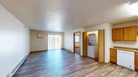 This single-floor unit offers a practical and functional layout designed for comfortable everyday living. The spacious living area is finished with durable laminate wood flooring and features a sliding glass door dressed with vertical blinds, allowing natural light to fill the space while providing access to the outdoors. A baseboard heating system and a wall-mounted AC unit ensure year-round climate control throughout the main living space.

The kitchen is well-appointed with warm honey-toned wood cabinetry offering generous storage, laminate countertops, and a full suite of white appliances including a refrigerator, electric range, built-in microwave, and dishwasher. A conveniently located in-unit stacked washer and dryer adds everyday practicality. The kitchen flows openly toward the living area, creating a connected and efficient space.

Two bedrooms are carpeted for comfort, each featuring a window for natural light and baseboard heating. The textured ceilings and warm wood trim are consistent throughout the unit.

Two full bathrooms feature wood-toned vanity cabinetry, single-basin sinks, large mirrors, and laminate wood flooring. One bathroom includes a tub/shower combination, while the other offers a walk-in shower, providing versatile options for residents.