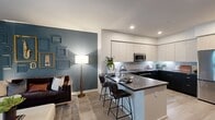North Grove A1E (Unit 5-103) is a thoughtfully designed 730-square-foot, one-bedroom, one-bathroom apartment located in Riverside, CA 92501. The single-floor layout maximizes efficiency while delivering a polished, contemporary aesthetic throughout. The open-concept kitchen and living area serves as the heart of the unit, featuring a striking two-tone kitchen with dark lower cabinets, white upper cabinetry, stainless steel appliances including a refrigerator, range, and microwave, gray quartz countertops, a subway tile backsplash, and a spacious island with bar seating. A bold, large-scale mural adds artistic character to the dining space. The living room offers light wood-style flooring, a deep teal accent wall, and access to a private outdoor patio complete with seating. The 130-square-foot bedroom features plush carpeting, a generous window with outdoor views, and direct access to both a walk-in closet and the hallway leading to the full bathroom. The bathroom includes a full soaking tub with shower, white tile surround, and a curved curtain rod. Additional highlights include two hallways, a dedicated closet, and an attached single-car garage with automatic opener. The overall ambiance is modern and artistic, blending functional design with stylish details.