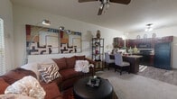 Located at 14600 N Rockwell Ave in Oklahoma City, OK, this one-bedroom, one-bathroom unit offers a well-designed single-floor layout that makes efficient use of its compact footprint. The open-concept living area flows naturally into the dining space and kitchen, creating a connected and functional common area. The living room features neutral carpeting, a ceiling fan with light fixture, and large windows with horizontal blinds that allow ample natural light to fill the space.

The kitchen is outfitted with rich, dark mahogany-toned cabinetry, granite-style countertops, black appliances including a range, microwave, dishwasher, and refrigerator, and durable wood-look plank flooring. A dedicated dining area adjacent to the kitchen provides a comfortable space for meals.

The generously sized primary bedroom is carpeted and features a ceiling fan, large windows with blinds for natural light and privacy, and sufficient space for full bedroom furnishings. A closet provides dedicated storage within the unit.

The bathroom continues the cohesive design aesthetic with matching dark wood cabinetry, a framed vanity mirror, and wood-look flooring. A washer is also visible in a utility area, indicating in-unit laundry access. Overall, the unit presents a warm, cohesive aesthetic throughout.
