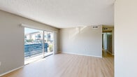 This single-floor residence offers a practical and comfortable layout with three bedrooms, three bathrooms, a living room, a kitchen, and two hallways connecting the spaces. Throughout the home, light-toned luxury vinyl plank flooring provides a clean, cohesive aesthetic, complemented by neutral warm-gray walls and white trim.

The living room is bright and open, featuring a textured ceiling and a large sliding glass door that invites natural light and provides outdoor views. The kitchen is well-equipped with white shaker-style cabinetry, light stone countertops, a decorative tile backsplash, and a full suite of stainless steel appliances including a refrigerator, dishwasher, and range.

The three bedrooms are each modestly sized and share the same light flooring and neutral palette. The primary bedroom offers a comfortable footprint, while the secondary bedrooms feature windows with slatted blinds that allow natural light while maintaining privacy. Each room provides a clean, move-in-ready feel.

The three bathrooms are thoughtfully appointed. Two feature tub-shower combinations with white tile surrounds and chrome fixtures, while the third includes a white vanity with a single sink and a well-lit mirror. The consistent use of light finishes throughout the bathrooms ties the home together with a fresh, cohesive design.