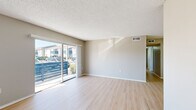 This single-floor residence offers a practical and comfortable layout with three bedrooms, three bathrooms, a living room, a kitchen, and two hallways connecting the spaces. Throughout the home, light-toned luxury vinyl plank flooring provides a clean, cohesive aesthetic, complemented by neutral warm-gray walls and white trim.

The living room is bright and open, featuring a textured ceiling and a large sliding glass door that invites natural light and provides outdoor views. The kitchen is well-equipped with white shaker-style cabinetry, light stone countertops, a decorative tile backsplash, and a full suite of stainless steel appliances including a refrigerator, dishwasher, and range.

The three bedrooms are each modestly sized and share the same light flooring and neutral palette. The primary bedroom offers a comfortable footprint, while the secondary bedrooms feature windows with slatted blinds that allow natural light while maintaining privacy. Each room provides a clean, move-in-ready feel.

The three bathrooms are thoughtfully appointed. Two feature tub-shower combinations with white tile surrounds and chrome fixtures, while the third includes a white vanity with a single sink and a well-lit mirror. The consistent use of light finishes throughout the bathrooms ties the home together with a fresh, cohesive design.