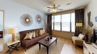 This single-story, 2-bedroom, 2-bathroom residence offers a thoughtfully designed layout that balances comfort and functionality. The living area features warm hardwood-style flooring, a ceiling fan, and large windows that invite natural light and outdoor views, creating an open and welcoming atmosphere. Eclectic décor elements, including industrial-style wall art, add character to the space.

The kitchen is efficiently laid out with light wood cabinetry extending to the ceiling for ample storage, black appliances including a refrigerator, range, microwave, and dishwasher, a double sink, and a breakfast bar that connects to the main living area. Track lighting illuminates the workspace effectively.

Both bedrooms are carpeted and equipped with ceiling fans. One bedroom features direct access to a private balcony through glass doors, enhancing the sense of space and providing outdoor views. The bedrooms are generously proportioned and offer a calm, neutral palette.

The two bathrooms are finished with light tile flooring and wood-toned vanity cabinetry. One bathroom includes a glass-enclosed walk-in shower, while the other features a shower-tub combination. Both offer clean, functional layouts with wide vanity mirrors.