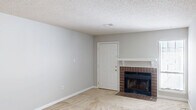 This single-story, 2-bedroom, 2-bathroom home in Augusta, Georgia offers a practical and comfortable layout designed for everyday living. The open living room serves as the heart of the home, featuring neutral-toned carpet, light gray walls, a textured ceiling, and a standout brick fireplace with a white mantel — an ideal focal point for the space. Natural light filters in through a window, adding brightness to the room.

The galley-style kitchen is efficiently laid out with white cabinetry, warm wood-tone laminate countertops, a double stainless steel sink, hardwood flooring, and a full suite of appliances including a black range and a white refrigerator. A pass-through window connects the kitchen to the adjacent living area.

Both bedrooms are carpeted and feature ceiling fans with light fixtures and windows that allow natural light in. Each room offers comfortable proportions, with the primary bedroom providing a generous amount of space. The bedrooms are served by two closets with louvered bifold doors, offering practical storage.

The two bathrooms include a full bath with a wood-look tile floor, a single-sink vanity with warm wood cabinetry, and a tub/shower combination, as well as a half bath for added convenience. A hallway connects the main living areas to the private bedroom wing, completing the functional floor plan.