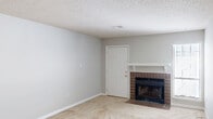 This single-story, 2-bedroom, 2-bathroom home in Augusta, Georgia offers a practical and comfortable layout designed for everyday living. The open living room serves as the heart of the home, featuring neutral-toned carpet, light gray walls, a textured ceiling, and a standout brick fireplace with a white mantel — an ideal focal point for the space. Natural light filters in through a window, adding brightness to the room.

The galley-style kitchen is efficiently laid out with white cabinetry, warm wood-tone laminate countertops, a double stainless steel sink, hardwood flooring, and a full suite of appliances including a black range and a white refrigerator. A pass-through window connects the kitchen to the adjacent living area.

Both bedrooms are carpeted and feature ceiling fans with light fixtures and windows that allow natural light in. Each room offers comfortable proportions, with the primary bedroom providing a generous amount of space. The bedrooms are served by two closets with louvered bifold doors, offering practical storage.

The two bathrooms include a full bath with a wood-look tile floor, a single-sink vanity with warm wood cabinetry, and a tub/shower combination, as well as a half bath for added convenience. A hallway connects the main living areas to the private bedroom wing, completing the functional floor plan.