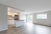 Located at 75 Mary St in Chatham-Kent, Ontario, this well-appointed 2-bedroom, 1-bathroom unit offers a clean, modern aesthetic throughout its efficiently designed single-floor layout. Light-toned vinyl plank flooring runs continuously through the space, creating a bright and cohesive feel.

A distinctive arched doorway serves as an architectural highlight, connecting the hallway to the open living and dining area. The living room is generously proportioned, offering ample natural light and a neutral color palette that provides a versatile backdrop.

The kitchen is thoughtfully designed with crisp white shaker-style cabinetry, recessed lighting, stainless steel appliances — including a refrigerator, stove, and microwave — and a peninsula with a laminate countertop that extends into the dining area, ideal for casual dining or additional prep space.

Both bedrooms are well-sized, featuring windows that bring in natural light and baseboard heating. The primary bedroom includes a mirrored sliding-door closet, adding both storage and a sense of spaciousness. The second bedroom also benefits from an outdoor view.

The bathroom features a full soaker tub and shower combination with elegant subway tile surround and chrome fixtures, completing this clean and functional space.
