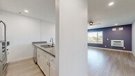 Located at 3710 Wabash Avenue in San Diego's North Park neighborhood, this two-bedroom, one-bathroom residence offers a practical and well-appointed single-floor layout. Light wood-style flooring runs throughout, complemented by crisp white walls and bold blue-gray accent walls that add a modern touch to the interior.

The open-concept kitchen and living area form the heart of the home. The kitchen features white cabinetry, gray countertops, a stainless steel double sink with a brushed gold faucet, a stainless steel refrigerator, an electric range, a built-in microwave, a dishwasher, and a mosaic tile backsplash. A peninsula with a blue accent base separates the kitchen from the living area, which is brightened by a large window with neighborhood views and a ceiling fan with a light fixture.

Both bedrooms are comfortably scaled and include sliding mirrored closet doors, with natural light entering through windows fitted with blinds. The primary bedroom features a distinctive blue-gray accent wall. A hallway connects the private areas of the home.

The full bathroom is finished with a white vanity, gray countertop, wood-style tile flooring, a full tub-shower combination, and a purple-gray accent wall, maintaining a cohesive design palette throughout the residence.