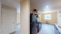 This single-story unit in Prineville, Oregon offers a well-organized layout with functional living spaces throughout. The galley-style kitchen is a standout feature, showcasing rich dark wood cabinetry with sleek bar-pull hardware, granite-patterned countertops, and wood-look vinyl flooring. Black appliances, including a refrigerator, electric range, microwave, and dishwasher, are integrated seamlessly into the design. Recessed lighting illuminates the kitchen's corridor layout, which provides ample upper and lower cabinet storage on both sides.

The living area is carpeted and generously sized, with warm neutral walls and multiple windows that invite natural light and offer views of the surrounding neighborhood. A private exterior door provides convenient outdoor access directly from the living space.

The bedrooms are carpeted and feature windows that bring in natural light. The unit includes two bathrooms: one with a tub-shower combination and grab bar, and another with a walk-in shower stall, each finished with wood-look flooring, granite-topped vanities, and dark wood cabinetry consistent with the kitchen's design. A hallway connects the main living areas to the private rooms, completing the practical and cohesive floor plan.
