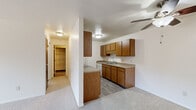 Located at 2487 Chestnut Hills Dr in Kalamazoo, MI, this one-bedroom, one-bathroom unit offers a practical and comfortable layout across a single floor. The kitchen is equipped with warm oak cabinetry spanning both upper and lower sections, a double-basin sink, a dishwasher, and a refrigerator, with durable wood-look vinyl flooring tying the space together. Adjacent to the kitchen, the main living area features neutral carpet, a ceiling fan with light fixture, and a built-in shelving closet that provides convenient storage. The entryway includes a solid front door, adding a sense of security and definition to the space. The bedroom is a bright, well-proportioned room with two windows that invite natural light and offer views of surrounding greenery. Baseboard heating units are present throughout, ensuring consistent warmth. The bathroom is notably spacious, featuring a split layout with dual vanity areas, oak cabinetry, white countertops, wood-look vinyl flooring, and a tub/shower combination. The clean, neutral color palette throughout creates a bright and welcoming atmosphere well-suited for comfortable everyday living.