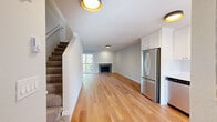 Located at 475 E North Bend Way in North Bend, Washington, this two-story, 2-bedroom, 2-bathroom home offers a thoughtfully laid-out living space spread across two floors. The main level features an open-concept kitchen and living area with warm hardwood flooring throughout. The kitchen is well-appointed with white shaker-style cabinetry, light countertops, and a full suite of stainless steel appliances including a refrigerator, range, microwave, and dishwasher. A window at the end of the kitchen brings in natural light and neighborhood views. The living room is anchored by a fireplace and receives ample natural light through a large window, creating a bright and welcoming atmosphere. A carpeted staircase leads to the upper level, which houses both bedrooms and a hallway. The primary bedroom offers a comfortable footprint with hardwood floors and generous natural light. The secondary bedroom also features hardwood flooring, a closet with sliding doors, and a window with a pleasant tree-lined view. Both bathrooms are clean and functional — one features a tub/shower combo with brushed nickel fixtures, while the other is a compact, well-finished space. The home's consistent use of hardwood flooring, neutral tones, and modern fixtures gives it a cohesive, move-in-ready feel.