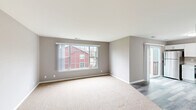 Located at 1157 S Wells St in Lake Geneva, Wisconsin, this 2-bedroom, 1-bathroom single-floor unit offers a well-designed layout with functional and modern finishes throughout. The living area is bright and inviting, featuring plush neutral carpeting, soft gray walls, and a large picture window that fills the space with natural light and provides views of the surrounding neighborhood. A sliding glass door adds additional light and leads to an outdoor deck, extending the living space outdoors. The kitchen is a standout feature, outfitted with crisp white shaker-style cabinetry, light countertops, and a full suite of stainless steel appliances including a refrigerator, range, microwave, and dishwasher. Light wood-tone flooring completes the clean, contemporary look. Both bedrooms are carpeted with neutral tones and feature ample closet space with built-in shelving, including a generously sized primary bedroom. The bathroom is finished with a dark vanity cabinet topped with a white countertop, a large mirror, and stylish light fixtures, complemented by the same wood-tone flooring found in the kitchen. Clean lines and a consistent neutral palette create a cohesive and comfortable atmosphere throughout this Lake Geneva residence.