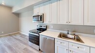 Located at 3805 Elwood Ave in Bellingham, WA, this efficiently designed single-floor studio offers a thoughtful layout that maximizes every square foot. The open living area is finished with light wood-tone flooring throughout, neutral warm-toned walls, and a ceiling fan with integrated lighting. A sliding glass door leads to a private balcony, allowing natural light to flood the space and providing outdoor views of the surrounding neighborhood.

The kitchen is well-appointed with a full suite of stainless steel appliances, including an electric range, over-the-range microwave, dishwasher, and refrigerator. Crisp white shaker-style cabinetry extends to the ceiling, offering generous storage, while a single-basin stainless steel sink and clean white countertops complete the functional workspace.

The bathroom features a full tub-and-shower combination with a white surround, chrome fixtures, and neutral beige-toned walls paired with wood-look tile flooring. A stacked washer and dryer unit is conveniently integrated into the main living area, adding practical in-unit laundry access. The overall ambiance of this studio is clean, modern, and move-in ready, making it a well-equipped and efficient living space in the Bellingham community.