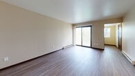 Located on Racine Ave in Muskego, Wisconsin, this single-floor, 2-bedroom, 1-bathroom residence offers a practical and comfortable layout designed for everyday living. Durable hardwood-style flooring runs consistently throughout the unit, complemented by neutral wall tones and dark wood trim that create a cohesive, clean aesthetic.

The open living area is spacious and inviting, featuring a ceiling fan and baseboard heating units for year-round comfort. It flows naturally toward the kitchen, which is equipped with warm-toned wood cabinetry, granite-look countertops, a white appliance suite including a refrigerator, range, and dishwasher, and a pass-through window that connects to the main living space.

The generously sized primary bedroom offers ample storage with dual sliding-door closets. The second bedroom also features hardwood-style flooring, a window with natural light, and a baseboard heater. Both rooms are served by a full bathroom appointed with a tub-shower combination and modern brushed nickel fixtures.

Throughout the unit, dark wood door frames and trim details provide consistent visual contrast against the light walls, contributing to a tidy and well-maintained interior. Baseboard heating is present in multiple rooms, ensuring efficient warmth during Wisconsin winters.