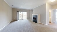 Located at 9701 Summit Cir in Upper Marlboro, MD, this well-designed three-bedroom, two-bathroom residence offers a comfortable and functional single-floor layout. The spacious living room serves as the heart of the home, featuring elegant crown molding, plush wall-to-wall carpeting, and a classic fireplace with a white surround and dark stone hearth. Sliding glass doors lead to a private balcony overlooking lush greenery and manicured grounds.

The kitchen is equipped with warm honey-toned cabinetry, white countertops, and black appliances including a range, refrigerator, and dishwasher. A peninsula with a breakfast bar seamlessly connects the kitchen to the living area, and light wood-look flooring ties the space together.

The three bedrooms are generously proportioned, each featuring soft carpeting and windows with blinds that invite natural light. The primary bedroom offers ample space and is complemented by two closets throughout the residence. The two bathrooms are clean and functional, featuring wood-look flooring, white vanities with mirrors, and tub-shower combinations — one equipped with accessibility grab bars for added convenience. A dedicated entrance provides a welcoming transition into the home.
