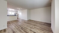 Located at 3245 W Avenue 32 in Los Angeles, this single-floor 2-bedroom, 2-bathroom unit offers a clean, modern aesthetic throughout. Wood-look luxury vinyl plank flooring runs consistently across all rooms, lending a cohesive and contemporary feel to the space.

The open living area is bright and expansive, with white walls and a neutral palette that maximize the sense of space. A sliding glass door opens onto a private balcony, allowing natural light to fill the room while providing views of the surrounding neighborhood greenery. A mirrored closet door along one wall adds additional visual depth to the living space.

The kitchen is well-appointed with white shaker-style cabinetry, gray countertops, and a full suite of stainless steel appliances including a gas range, microwave, dishwasher, and refrigerator. A window above the sink provides natural light and ventilation.

Both bedrooms are comfortably sized with clean white walls and wood-look flooring. The spacious primary bedroom includes direct access to a private bathroom. Both bathrooms follow a consistent design, featuring tub-shower combinations with curtains, glass shelving, and white vanities, maintaining the unit's clean, functional aesthetic throughout.