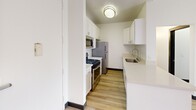 Located at 13801 Paramount Blvd in Paramount, CA, this 2-bedroom, 2-bathroom residence offers a thoughtfully designed single-floor layout with a clean, modern aesthetic throughout. Light wood flooring flows seamlessly across all rooms, complemented by crisp white walls and dark trim accents that create a polished contrast.

The bright living room serves as the heart of the home, featuring a classic fireplace with a built-in shelving unit alongside it, and sliding glass doors with vertical blinds that open to an outdoor area and allow generous natural light to fill the space. The kitchen is efficiently designed in a galley style with white shaker cabinetry, stainless steel appliances including a gas range, microwave, and refrigerator, plus ample counter space and a sink.

The spacious primary bedroom includes a sliding mirrored closet and convenient access to its own bathroom. A second bedroom with a ceiling fan offers additional built-in closet storage. Both bathrooms are cleanly finished, with one featuring a full shower-tub combination and recessed shelving. Two dedicated closet spaces, including a walk-in with multi-shelf built-ins and hanging rods, provide excellent storage throughout this well-organized home.