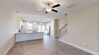 Located at 272 Dolcetto Dr in Winder, GA, this two-story home offers a well-designed layout across two floors. The main level welcomes you through a dedicated entrance into an open-concept living area with warm hardwood-style flooring and ceiling fans throughout. The kitchen is a standout, featuring crisp white shaker cabinetry, granite countertops, a subway tile backsplash, stainless steel appliances including a refrigerator, range, microwave, and dishwasher, and a central island with pendant lighting. French doors at the rear of the main level bring in natural light and provide outdoor access. A staircase with wood treads and iron balusters connects the floors. The upper level hosts all three bedrooms, including a generously sized primary suite, carpeted throughout for comfort. Three full bathrooms serve the home. A dedicated laundry room on the upper floor is equipped with a front-loading washer and dryer. Additional storage is provided by a closet, and two hallways ensure smooth circulation between rooms. Neutral tones and clean finishes throughout give the home a fresh, move-in-ready feel.