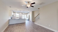 Located at 272 Dolcetto Dr in Winder, GA, this two-story home offers a well-designed layout across two floors. The main level welcomes you through a dedicated entrance into an open-concept living area with warm hardwood-style flooring and ceiling fans throughout. The kitchen is a standout, featuring crisp white shaker cabinetry, granite countertops, a subway tile backsplash, stainless steel appliances including a refrigerator, range, microwave, and dishwasher, and a central island with pendant lighting. French doors at the rear of the main level bring in natural light and provide outdoor access. A staircase with wood treads and iron balusters connects the floors. The upper level hosts all three bedrooms, including a generously sized primary suite, carpeted throughout for comfort. Three full bathrooms serve the home. A dedicated laundry room on the upper floor is equipped with a front-loading washer and dryer. Additional storage is provided by a closet, and two hallways ensure smooth circulation between rooms. Neutral tones and clean finishes throughout give the home a fresh, move-in-ready feel.