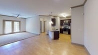 Located at 99 Turtle Creek Dr., this single-floor residence offers a well-designed open-concept layout that seamlessly connects the living area and kitchen. The main living space features light wood-tone flooring that extends throughout the common areas, complemented by neutral-toned walls and crown molding details that add a refined touch to the interior.

The kitchen is outfitted with dark espresso cabinetry, granite countertops, a white subway tile backsplash, and a full suite of stainless steel appliances, including a range, over-the-range microwave, and refrigerator. A peninsula with pendant lighting above provides additional counter space and serves as a natural divider between the kitchen and living areas.

The bedrooms are carpeted for comfort and include ceiling fans with lighting. One bedroom features direct access to an exterior door, allowing for natural light and outdoor access. Interior doors throughout are a coordinated gray tone, providing a cohesive aesthetic.

Two bathrooms serve the unit, each finished with dark vanity cabinetry, granite countertops, undermount sinks, and warm tile flooring. One bathroom includes a shower/tub combination, while the other functions as a half or secondary bath. Together, the spaces create a clean, functional, and cohesive living environment.