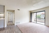 Located at 1251 Massachusetts Ave in Riverside, CA, this single-floor residence offers 2 bedrooms and 2 bathrooms within a thoughtfully organized layout. The living room is a bright, open space featuring soft carpeting, wood-style flooring at its entry transition, a textured ceiling, and a sliding glass door that opens directly onto a private balcony with outdoor views. The adjacent dining area connects seamlessly to the kitchen, which features white cabinetry, light quartz-style countertops, a stainless steel refrigerator, a gas range, and a peninsula with a sink — ideal for both cooking and casual interaction with the living and dining areas. The primary bedroom is generously sized, offering dual sliding-door closets and plush carpeting, while the secondary bedroom includes its own closet and additional storage access. Both bathrooms are finished with wood-style vinyl flooring and full tub-shower combinations with clean, white surrounds. The unit also includes four closets total, two utility rooms, and a hallway that efficiently connects all areas. The overall aesthetic is clean and neutral, with light walls and consistent finishes throughout, creating a bright and functional living environment.