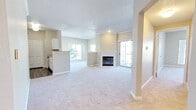 Located at 6743 W Ida Pl in Littleton, Colorado, this single-floor residence offers a bright, open layout designed for comfortable everyday living. The main living area is generously proportioned, featuring plush wall-to-wall carpeting, a classic white-mantled fireplace as a central focal point, and a textured ceiling that adds subtle character. Large windows and a sliding glass door bathe the space in abundant natural light while providing views of the surrounding greenery and easy access to the outdoors. The open-concept design connects the living area seamlessly to the kitchen pass-through, enhancing the sense of spaciousness. The kitchen is well-appointed with white cabinetry, light countertops, stainless steel appliances including a range, over-the-range microwave, refrigerator, and dishwasher, as well as durable wood-look flooring that adds warmth and practicality. The bedroom offers comfortable proportions with soft carpeting and a large window that frames outdoor views and fills the room with natural light. The bathroom features a full soaking tub and shower combination with clean white tile surround and wood-look flooring. Neutral, warm tones are carried throughout the entire residence, creating a cohesive and inviting ambiance from room to room.