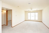 This single-floor unit offers a straightforward, functional layout designed for comfortable everyday living. The open living area is finished with neutral-toned carpet and anchored by a ceiling fan with integrated lighting, creating a simple and airy atmosphere. The space flows directly into the kitchen, which is outfitted with warm oak cabinetry, light countertops, and tile flooring. White appliances, including a refrigerator, electric range, built-in microwave, and dishwasher, provide all essential cooking and cleaning conveniences. Ample upper and lower cabinet storage makes the kitchen both practical and well-organized.

The bedroom features plush carpeting, a ceiling fan, and two windows that allow natural light to fill the room, lending it a bright and pleasant feel. A double-door closet offers generous storage capacity. The full bathroom includes a wood-toned vanity with an integrated sink, a wall-mounted mirror with overhead lighting, tile flooring, and a full-size tub and shower combination. Throughout the unit, warm wood-toned trim and doors provide visual consistency, while the neutral color palette creates a clean and versatile backdrop suitable for a variety of interior styles. The overall design prioritizes practicality and ease of living.