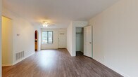This single-floor residence is designed with a clean, functional layout that connects living, sleeping, and kitchen areas in a cohesive flow. Wood-style plank flooring runs consistently throughout the unit, lending a warm, unified aesthetic to every room.

The living area is notably spacious, anchored by a ceiling fan and illuminated by a front-facing window alongside a large sliding glass door fitted with vertical blinds, offering views of surrounding greenery and filling the room with natural light. A charming arched passageway connects the living space to the kitchen, adding a subtle architectural detail. The entry door features decorative glass panels, and a built-in closet near the entry provides convenient storage.

The kitchen is equipped with warm-toned wood cabinetry, stone-pattern countertops, a stainless steel sink, gas range, over-the-range microwave, and a stainless steel dishwasher. A window above the sink brings in additional natural light.

The bedrooms are generously proportioned, each with wood-style flooring, vertical-blind windows offering outdoor views, and ceiling-mounted HVAC vents. The bathroom features a full tub-shower combination with a neutral surround and classic mosaic tile flooring, maintaining a practical and tidy finish throughout.
