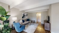 Located on E Evans Ave in Denver, CO, this 1-bedroom, 2-bathroom residence offers a well-designed single-floor layout that maximizes every square foot. The living room is bright and inviting, featuring rich hardwood-style flooring, distinctive exposed ceiling beams, and a textured ceiling. Large windows with vertical blinds frame views of the outdoors and flood the space with natural light, creating an open and airy atmosphere throughout.

The galley-style kitchen is efficiently designed with white shaker cabinetry, stone-look countertops, wood-look tile flooring, and white appliances including a range, dishwasher, and refrigerator — offering ample storage and workspace along both sides.

The primary bedroom is generously proportioned, featuring plush carpeting, a bold teal accent wall, exposed ceiling beams, a large window, and a dedicated closet with built-in shelving. Two hallways connect the key areas of the unit, supporting a functional flow throughout.

Both bathrooms are finished with wood-look flooring and white cabinetry. The full bath includes a tub-shower combination with white tile surround, while the second bath features a vanity with stone-look countertops and modern light fixtures. Two hallways provide practical connectivity between all rooms, rounding out this well-appointed Denver residence.