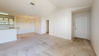 Located at 1861 Stella Ln in Fort Walton Beach, FL, this 2-bedroom, 2-bathroom single-floor home offers a well-organized layout with a clean, neutral aesthetic throughout. The living room is a standout space, featuring vaulted ceilings, plush carpeting, and a pendant chandelier, creating an open and airy atmosphere. Natural light filters in through windows and a glass-panel exterior door, enhancing the bright, welcoming feel. The galley-style kitchen is efficiently designed with white cabinetry, laminate countertops, tile flooring, and white appliances including a range, microwave, and refrigerator, with ample upper and lower cabinet storage. Both bedrooms feature soft carpeting and ceiling fans with light fixtures. The generously sized primary bedroom includes a walk-in closet equipped with wire shelving, providing practical storage solutions. The second bedroom also benefits from natural light and its own closet access. The home includes four closets in total, offering excellent storage throughout. Both bathrooms are finished with tile flooring, white cabinetry, and tub/shower combinations. The neutral color palette and consistent finishes across all rooms give the home a cohesive and move-in-ready appearance.