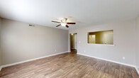 Located in Clemmons, NC, this single-story, 2-bedroom, 1-bathroom home offers a practical and comfortable layout designed for everyday living. The open living room is a welcoming focal point, featuring warm wood-look flooring, neutral gray walls, crisp white baseboards, and a ceiling fan with a light fixture that keeps the space bright and airy. A distinctive pass-through window connects the living room to the kitchen, promoting an open feel between the two spaces. The kitchen is well-equipped with white shaker-style cabinetry, a black refrigerator, a black electric range with an overhead exhaust fan, and matching wood-look flooring that ties the main living areas together cohesively. The spacious primary bedroom is carpeted for comfort and includes a ceiling fan, a natural light-bringing window with blinds, and the added convenience of two closets. The second bedroom also features plush carpeting and neutral tones, offering a clean and versatile space. The bathroom includes a white vanity with a large mirror and ample counter space. A hallway connects the bedrooms and bathroom, completing the efficient floor plan. Throughout the home, the consistent neutral palette and durable finishes create a clean, move-in-ready aesthetic.